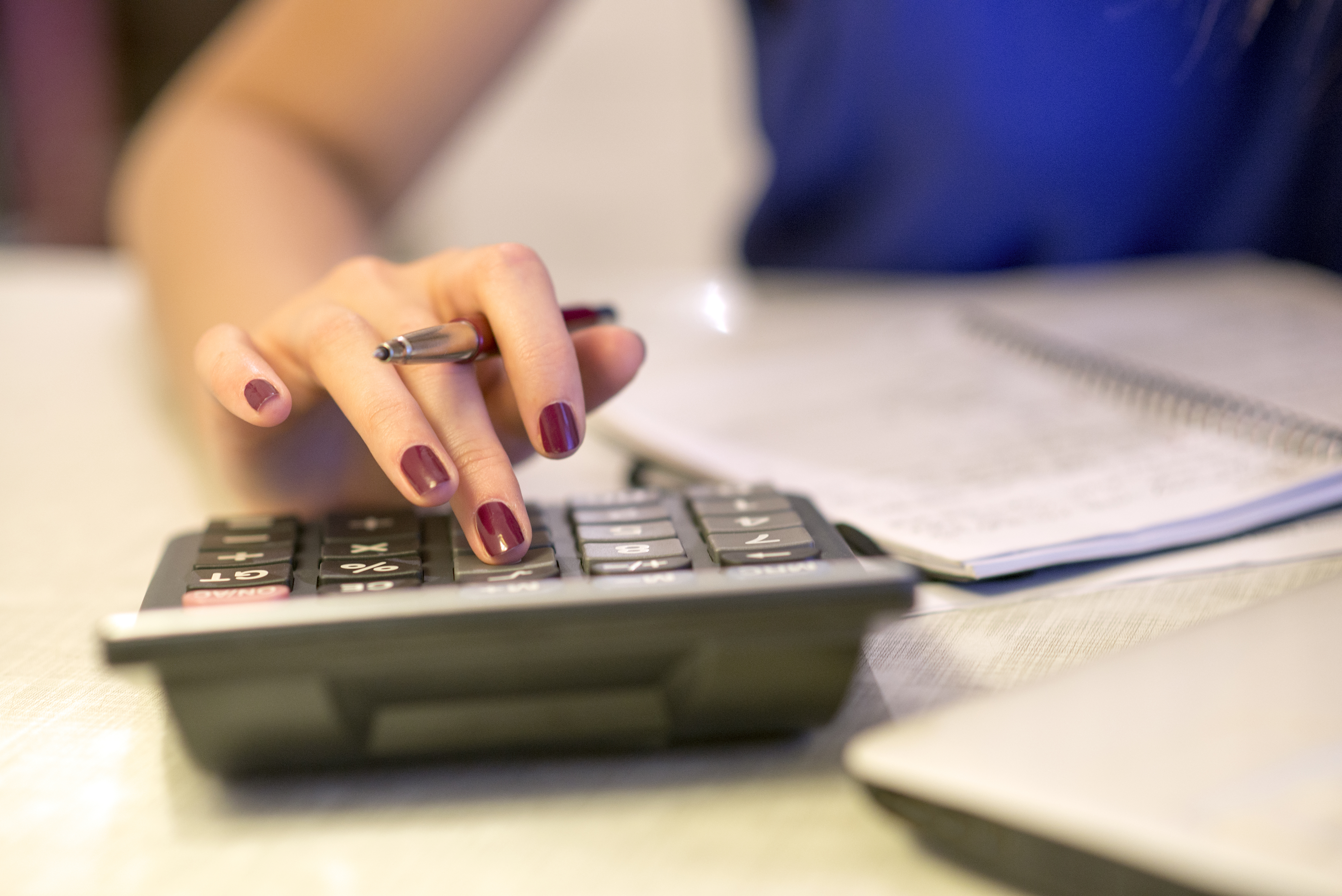 woman typing on calculator 