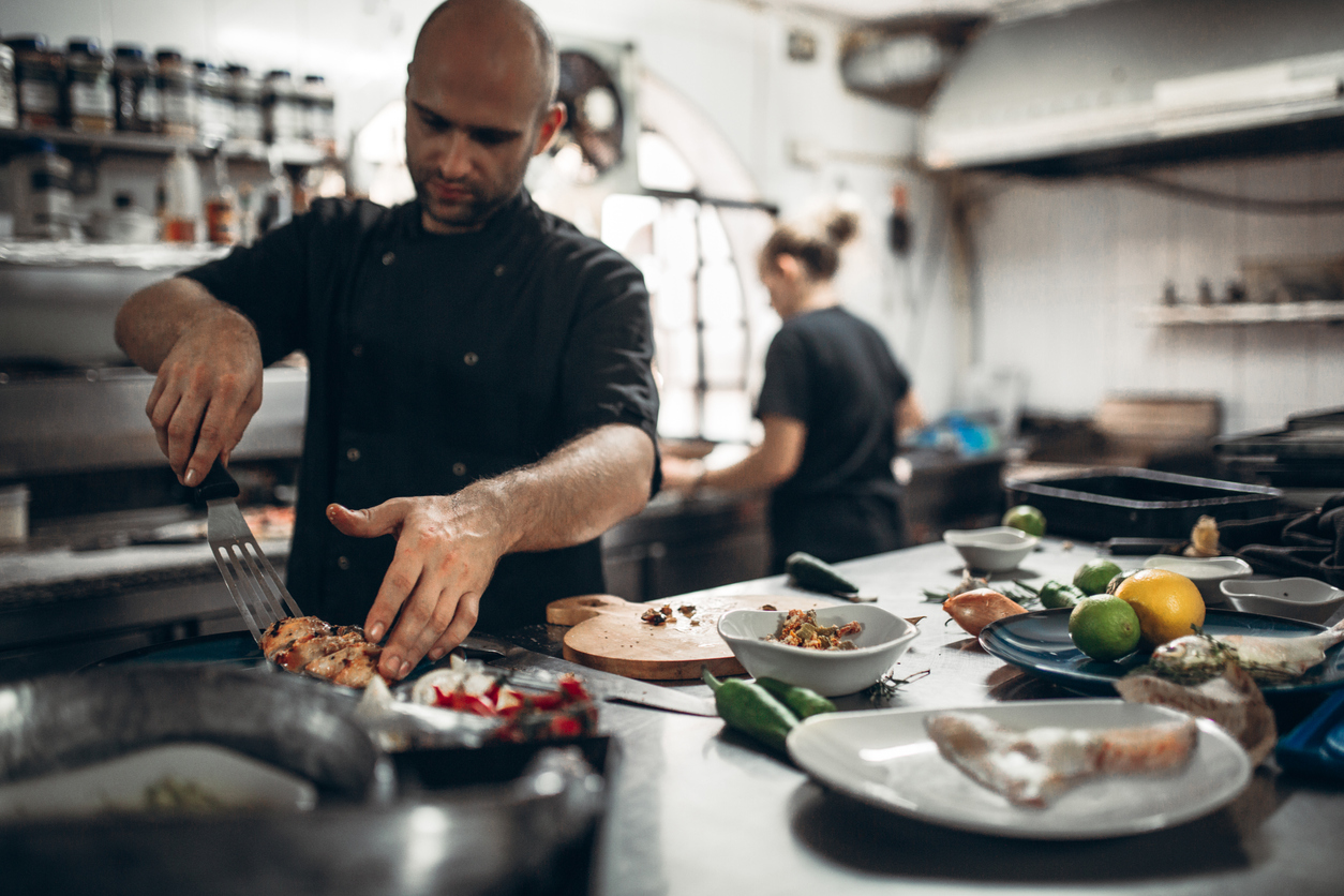 Cooks in restaurant plating seafood 