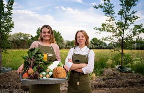 2 female farmers holding vegetables