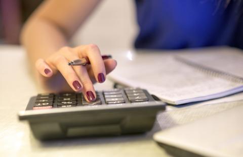 woman typing on calculator 