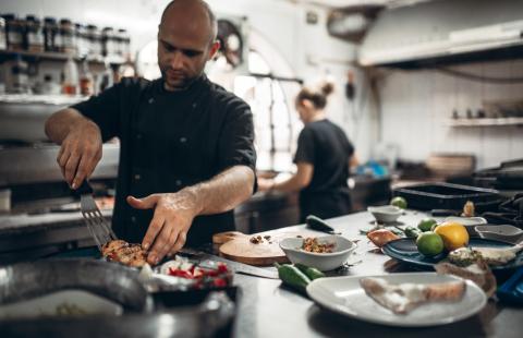 Cooks in restaurant plating seafood 